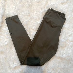 Green Nike leggings with tight fit, mid rise, and full length.